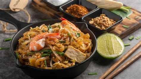 Persona preparando Pad Thai en un wok
