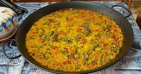 Arroz redondo en la paellera con caldo y verduras