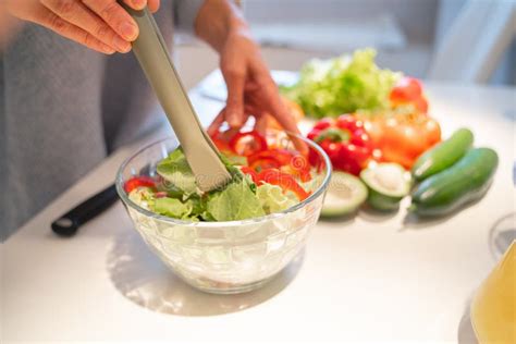 Mezclando ingredientes de ensalada en un bol grande