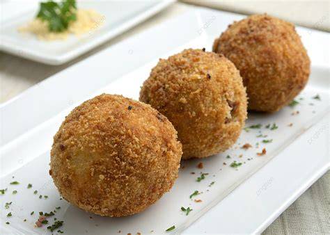 Croquetas doradas servidas en un plato elegante con decoración