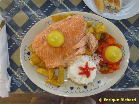 Plato de trucha servido con papas y ensalada