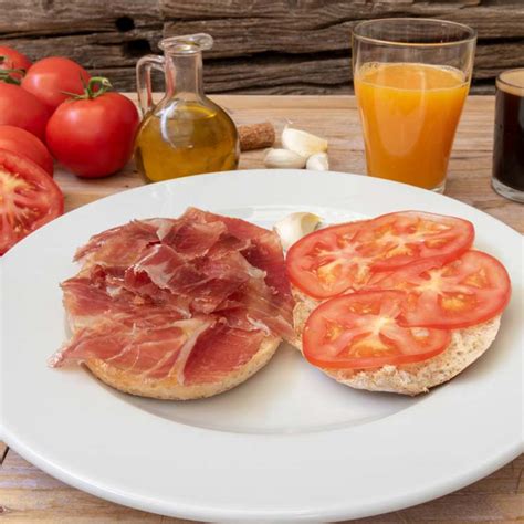 Desayuno andaluz con molletes, jamón, tomate y aceite