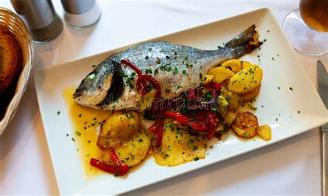 Dorada frita servida con patatas