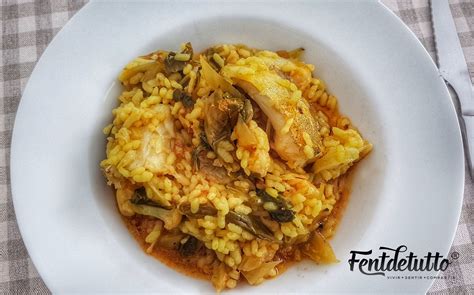 Arroz meloso con bacalao y coliflor en una paellera