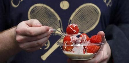 Aficionados en Wimbledon degustando fresas con nata