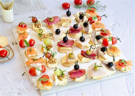 Variedad de canapés listos para servir en una mesa de verano