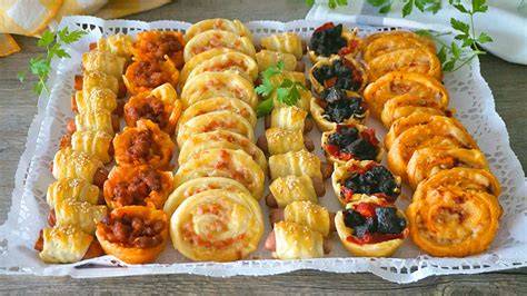 variedad de bocaditos de hojaldre dulces y salados presentados en una mesa