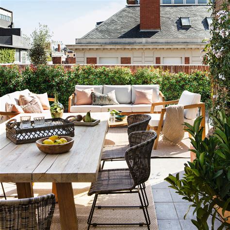 Terraza al aire libre de Le Jardin Des Envies con mesas y vegetación