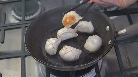 Gyozas dorándose en sartén