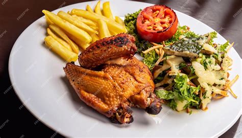 Plato de pollo a la brasa con papas fritas y ensalada