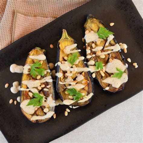 Berenjenas a la brasa servidas con tahini y perejil