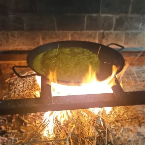 Paellera tradicional cocinándose a fuego de leña