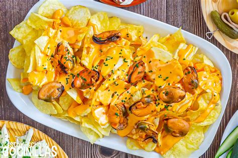 Plato servido de mejillones en salsa de mostaza con papas fritas