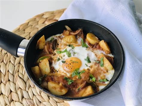 Sartén con bacalao, patatas y huevos cuajándose