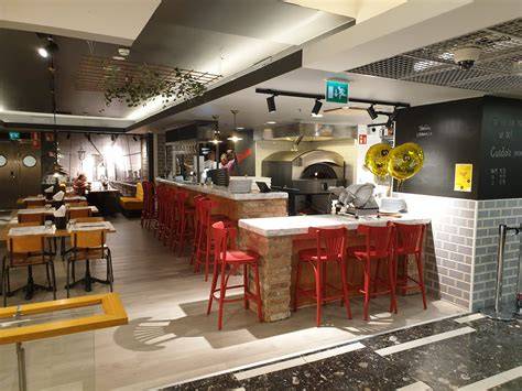 Interior de la Pizzería Duo con mesas y banquetas