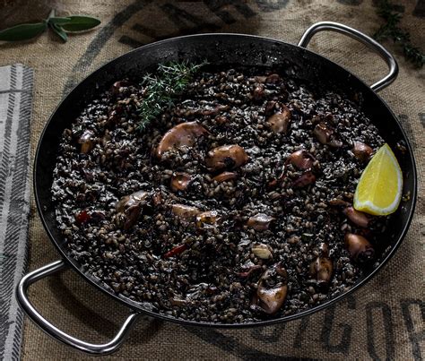 Paellera con arroz negro en cocción