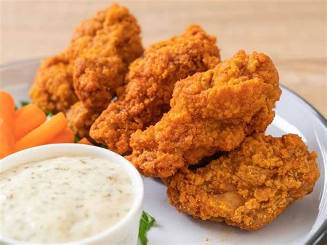 Alitas de pollo fritas estilo Kentucky servidas con salsa tártara