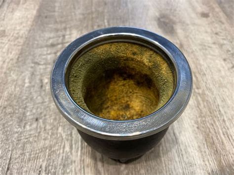 Interior de una calabaza de mate con manchas negras y verdes