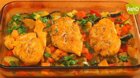 Bandeja de horno con pechugas de pollo, patatas y zanahorias listas para cocinar