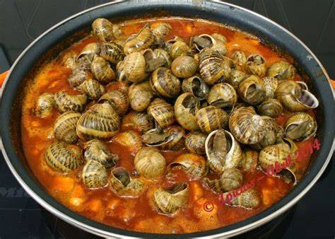 Plato de caracoles servidos con arroz y marisco