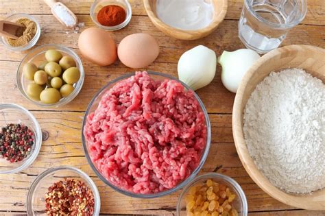 Ingredientes frescos para el relleno de empanadas, incluyendo carne cortada a cuchillo, cebolla, pimiento y especias.