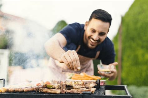 Persona sazonando carne a la parrilla