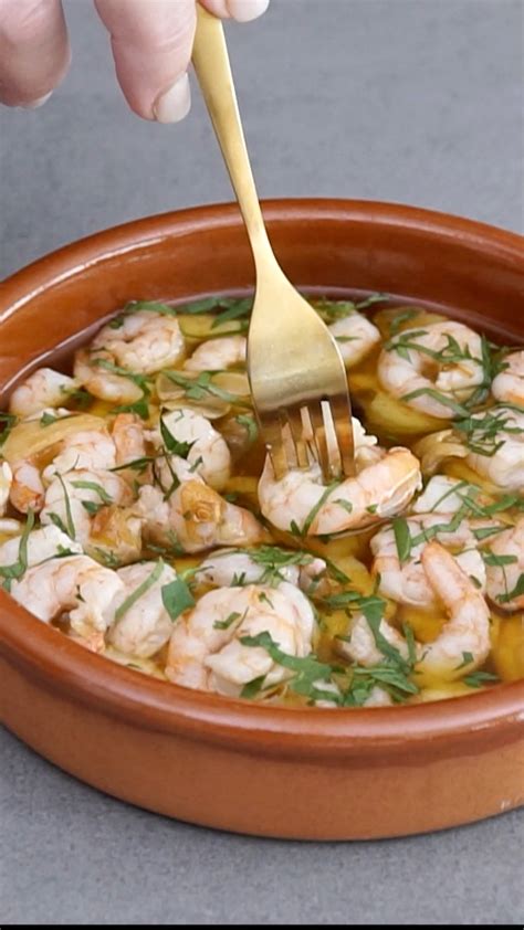 Sartén con ajos dorándose y gambas