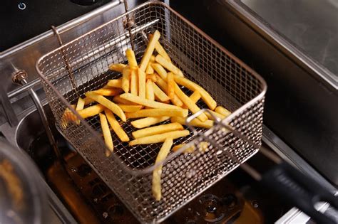 Freidora industrial con patatas fritas doradas