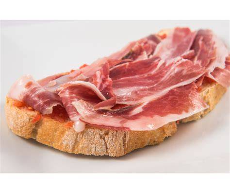Tostada de pan con tomate y jamón serrano recién preparada