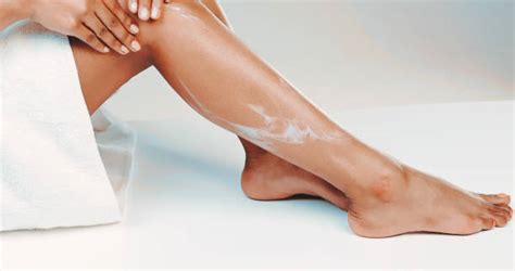 Mujer aplicando aceite corporal en sus piernas
