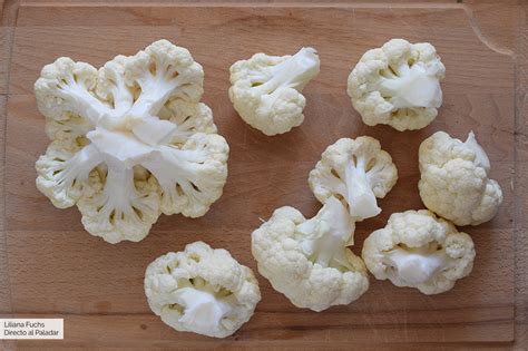Manos separando ramilletes de coliflor