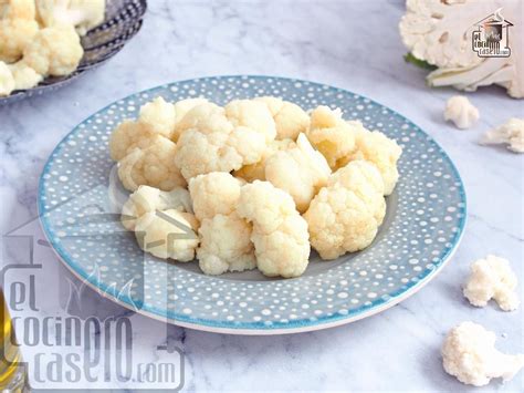 Coliflor cocinándose al vapor en una vaporera con hierbas aromáticas
