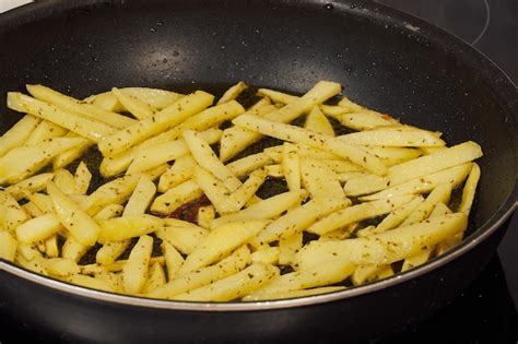 Patatas cortadas en taquitos y friéndose en aceite caliente