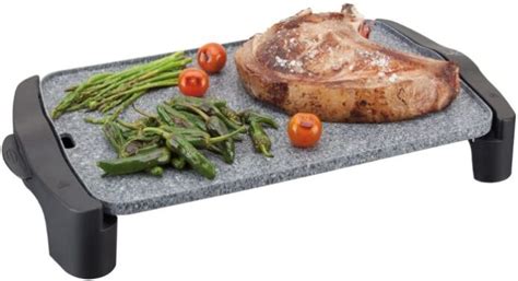 Plancha de asar de piedra con alimentos cocinándose