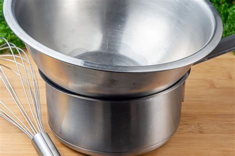 Molde para budín dentro de una fuente con agua, preparado para baño María