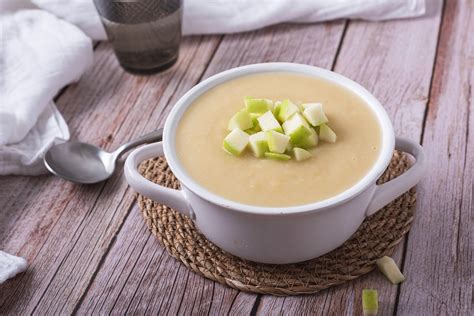 Vichyssoise de manzana en un bol, decorada con trozos de manzana y cebollino