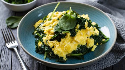 Huevos verdes con jamón y espinacas en un plato