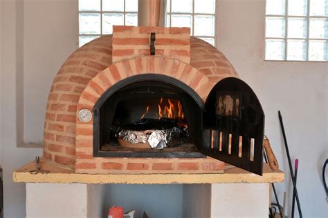 Un horno de leña portátil con un cordero asándose