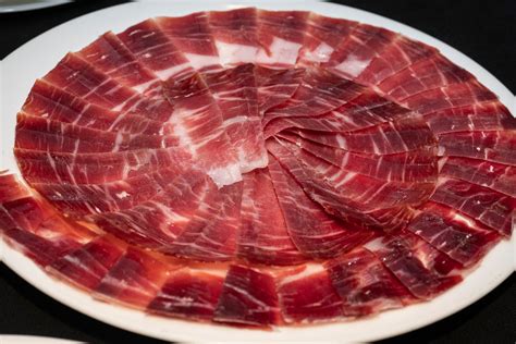 Plato de jamón ibérico recién cortado con pan y aceite de oliva