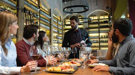Clientes disfrutando de tapas y vino en una terraza de restaurante