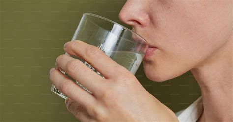 Ilustración de una persona bebiendo de un vaso sin pajita después de una extracción dental