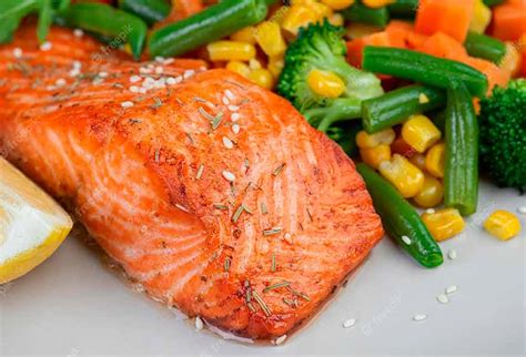 Rodajas de salmón dorándose en el horno con verduras