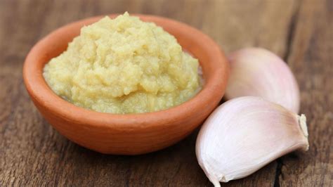 Ajos frescos y pasta de ajo en un recipiente