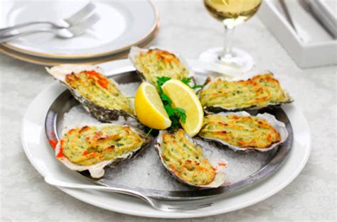Ostiones gratinados servidos con rodajas de limón y ciboulette