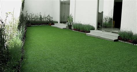 Patio pequeño con pasto sintético y mobiliario minimalista