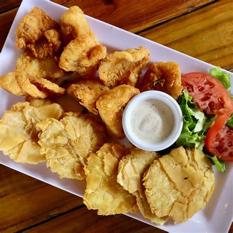 Chicharrones servidos con tostones y limón