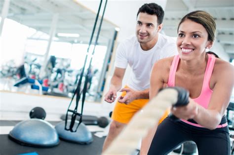Entrenador personal trabajando con un cliente en un centro de fitness