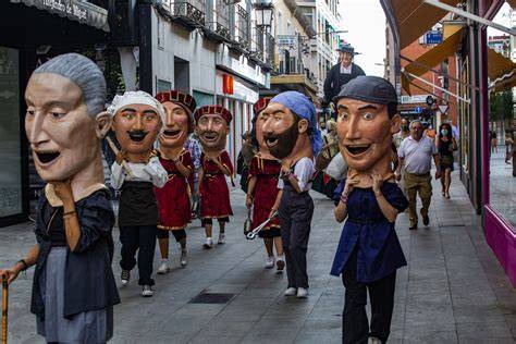 Ilustración de un desfile de gigantes y cabezudos, origen de la Tomatina