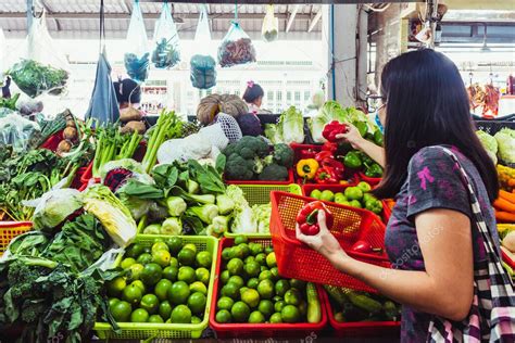 Mujer comprando verduras ecológicas en un mercado de Alicante