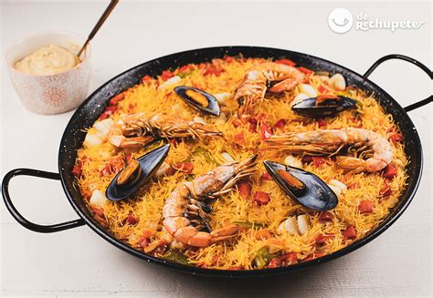 Paella y fideuá en la playa al atardecer